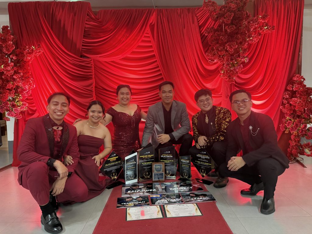 The six-member RAC Makati delegation in formal wear kneel with their GEAR Awards 2026 trophies on the red carpet.