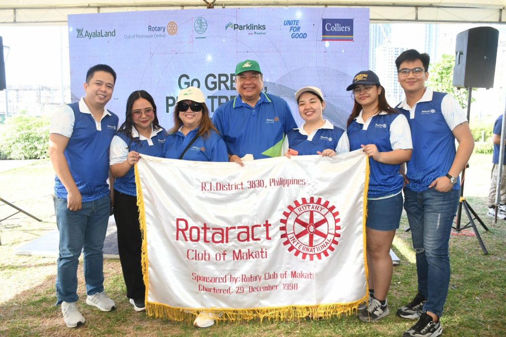 Rotaract Club of Makati members hold the club banner at the “Go Green, Plant Trees at Parklinks” activity.