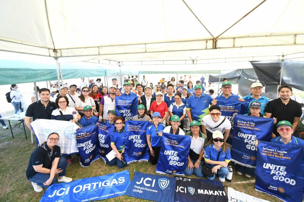 More than 120 Rotarians and Rotaractors gather with partner-club banners at Parklinks Eco Forest.
